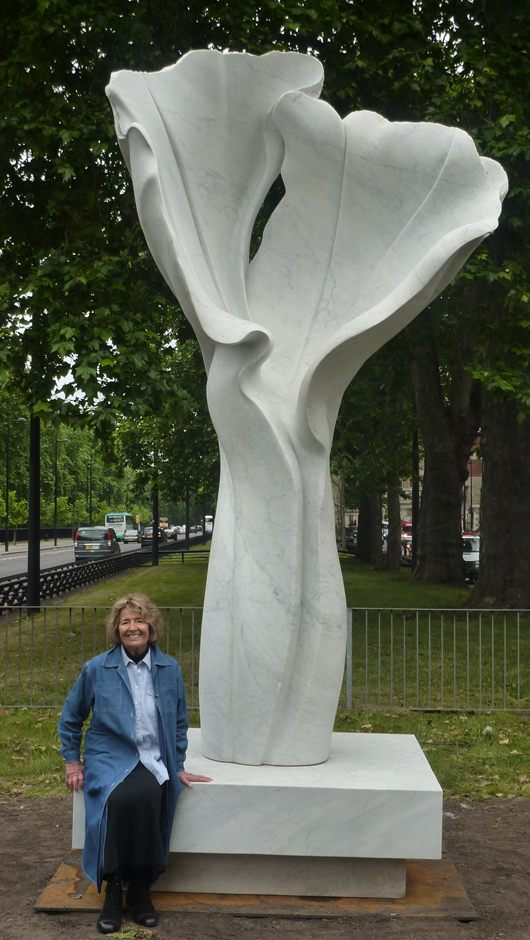 Cambridge-based sculptor Helaine Blumenfeld, sitting beside her 2007 work titled ‘Spirit of Life,’ recently installed on a plinth near the Dorchester Hotel in Park Lane. Image courtesy of Helaine Blumenfeld and Robert Bowman Ltd., London.